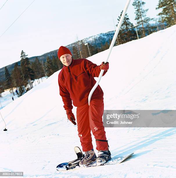 man in red snowboarding - tellerlift stock-fotos und bilder