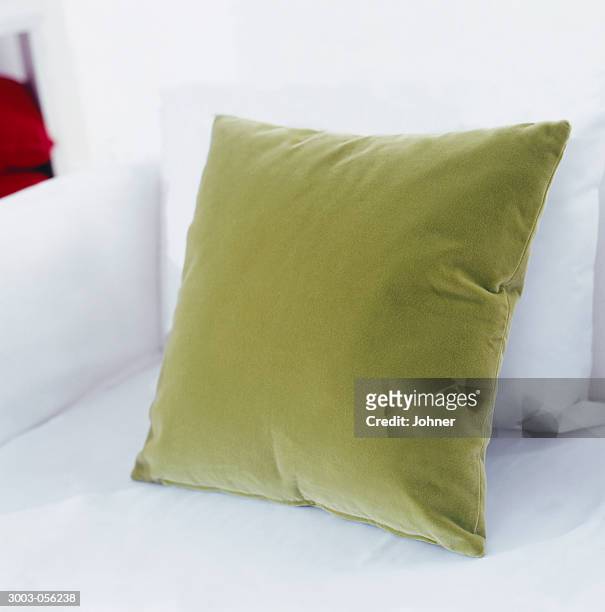 green cushion on sofa - cushion stockfoto's en -beelden