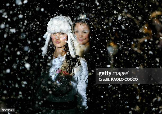 Model walks under artificial snow during Blumarine's underwear collection at ng Milan's Autumn/Winter fashion week 22 February 2004. AFP PHOTO/Paolo...