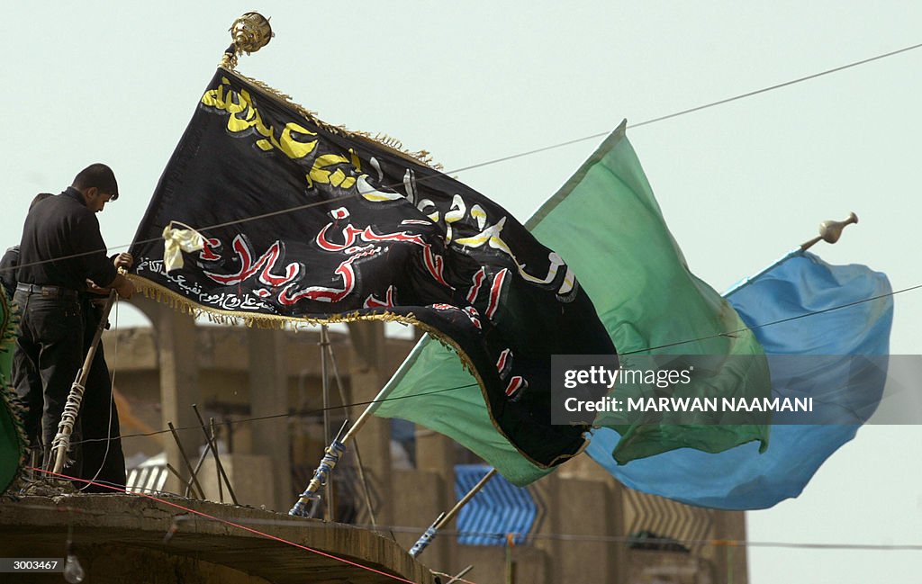 An Iraqi Shiite Muslim fixes a huge blac