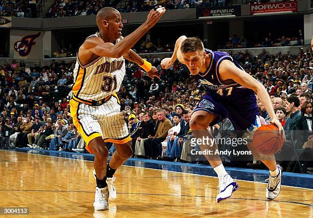 Andrei Kirilenko of the Utah Jazz dribbles towards the basket as Reggie Miller of the Indiana Pacers defends during the NBA game at Conseco...