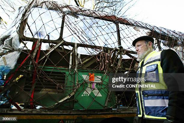 Member of the Israelian organisation ZAKA stands near the wreckage of a bus destroyed by a suicide attack in Jerusalem in January 2004 near the...