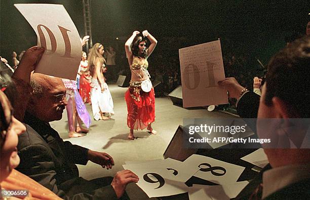 The jury is giving marks to the contestants while gipsy girls perform a belly dance during the Miss Piranda contest 22 February 2004, in Bucharest....