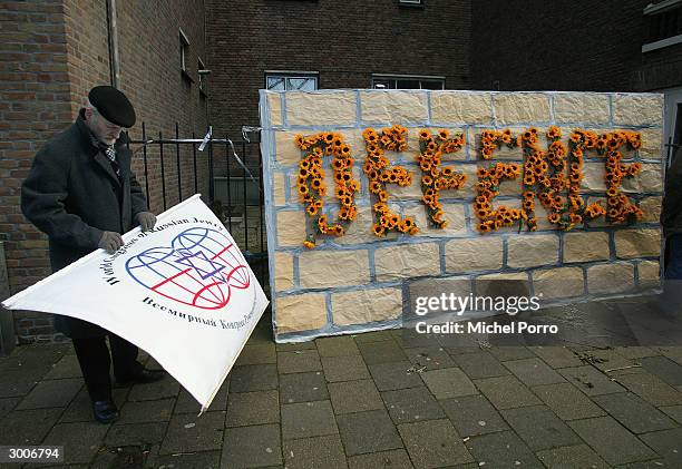 An Israeli proteser wraps up his banner outside the International Court of Justice February 23, 2004 in The Hague, The Netherlands. A case is being...