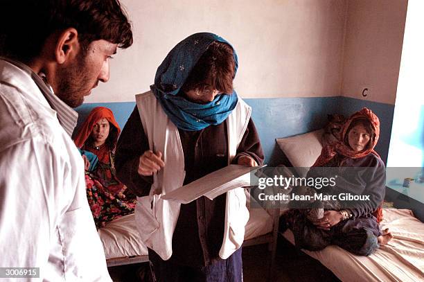 Pediatrician Dr. Marian Rodriguez Blanco reviews the files of patients staying at the MSF clinic with Dr. Amel November 19, 2003 in Dagah,...