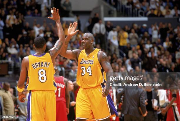 Shaquille O'Neal of the Los Angeles Lakers high-fives teammate Kobe Bryant during the game against the Portland Trail Blazers at Staples Center on...