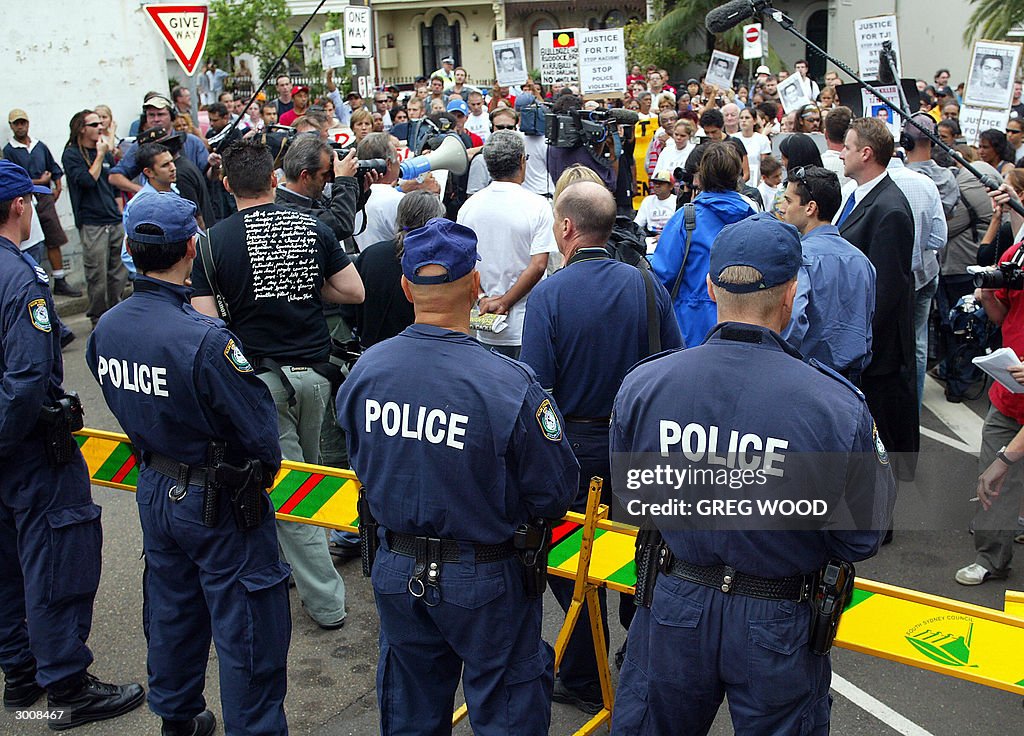 Redfer Riots Police watch members of the Redfern Aboriginal community, as they ...