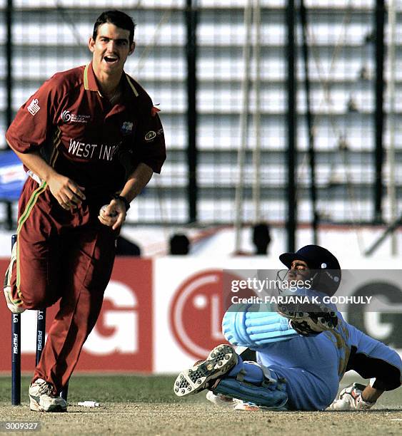 Indian U19 cricketer Dinesh Karthik looks back towards West Indies bowler Jonathan Augustus as he celebrates running out Karthik during an Under 19...