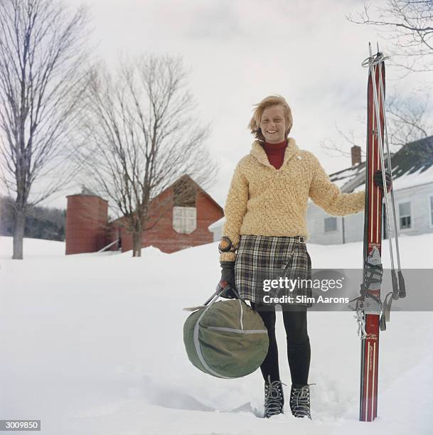 Ski 'bum' Alice Clement, a waitress and dishwasher at Stowe, Vermont when not on the slopes, carrying her skis on the way to a run, circa 1960. A...