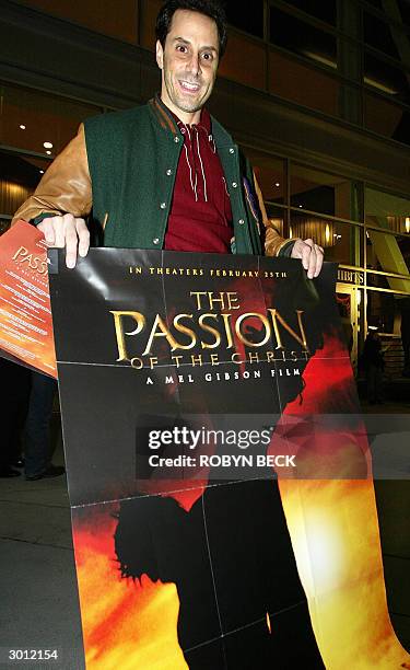 Movie-goer Joseph Camerieri of Clearwater, Florida holds a poster from Mel Gibson's "The Passion of The Christ" early 25 February 2004 outside the...