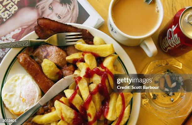 Typical English breakfast of bacon, eggs, sausages and chips sits ready to be eaten at a greasy spoon cafe February 25, 2004 in London. Britain's...