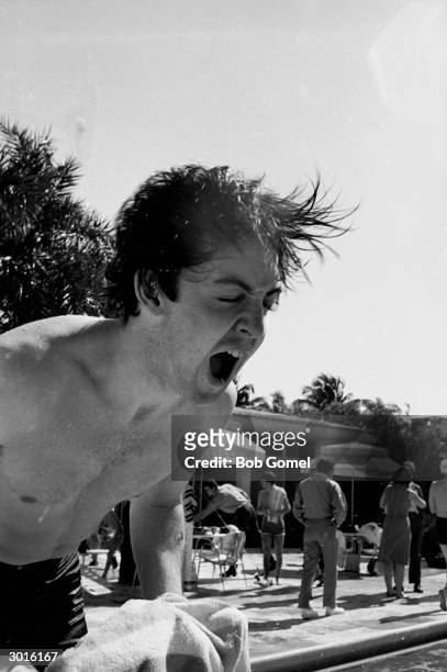 British musician Paul McCartney of the Beatles shakes out his wet hair beside a swimming pool, Miami Beach, Florida, February 1964.