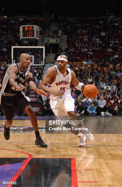 Vince Carter of the Toronto Raptors drives around Bruce Bowen of the San Antonio Spurs during the game at Air Canada Centre on February 18, 2004 in...