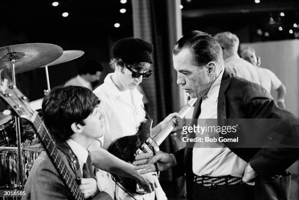 View of British Rock musicians Paul McCartney and John Lennon with American television host Ed Sullivan during a rehearsal for 'The Ed Sullivan Show'...