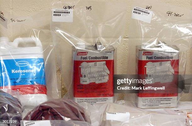 Gallon sized canisters of kerosene and camping fuel, bagged as evidence, are shown on display at the Jefferson County Fairgrounds February 26, 2004...