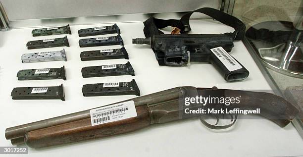 Sawed off double barrel shotgun, ammuntion clips and an automatic pistol used in the 1999 Columbine High School shooting are displayed in a glass...