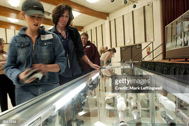 Two unidentified women look into a glass display case, at the Jefferson County Fairgrounds, which holds several pipe bombs and other weapons...