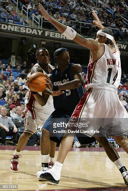 Josh Howard of the Dallas Mavericks is defended by Ira Newble and Dajuan Wagner of the Cleveland Cavaliers during the game at Gund Arena on February...