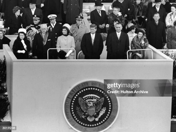 American President John Fitzgerald Kennedy stands on a platform for his inauguration as 35th President on the east front of the US Capitol, January...