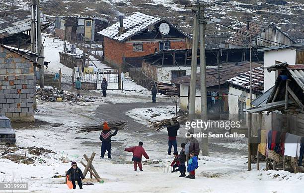 Roma, or Gypsies, carrying wood to heat their homes return to the slum February 26, 2004 near Bystrany in eastern Slovakia. Several thousand people...