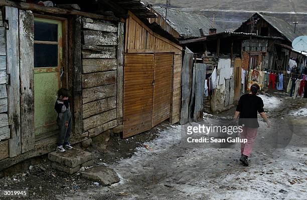 Roma child stands in the doorway of its home while a family member goes to fetch drinking water from the local well February 26, 2004 in the Roma, or...