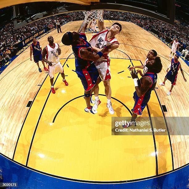 Yao Ming of the Western Conference All-Stars dunks against Jermaine O'Neal of the Eastern Conference All-Stars during the 2004 All-Star Game on...