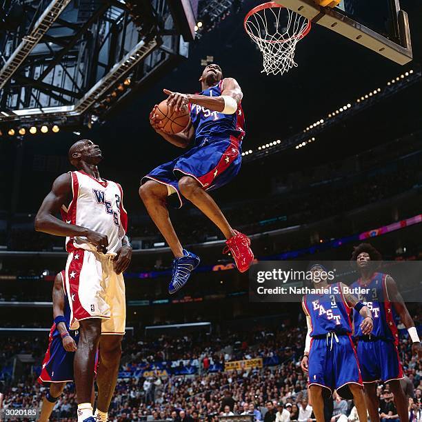 Tracy McGrady of the Eastern Conference All-Stars dunks against Kevin Garnett of the Western Conference All-Stars during the 2004 All-Star Game on...