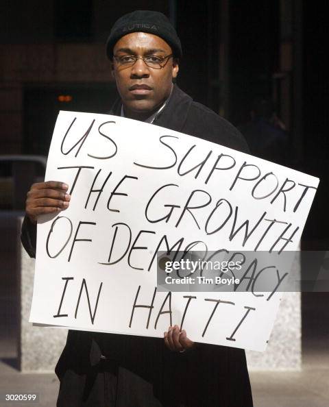 Kwame Riots Demonstration participant Kwame Raoul displays his sign during a ...