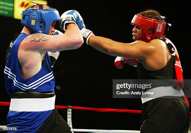 Jason Estrada of Providence, Rhode Island lands a punch during his super heavyweight match against Mike Wilson of Central Point, Oregon during the...