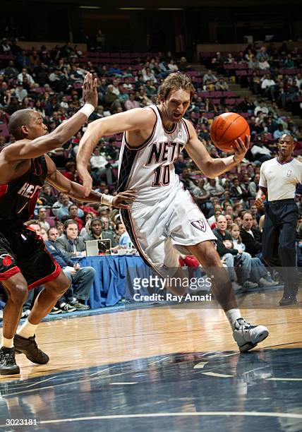 Zoran Planinic of the New Jersey Nets drives to the basket against Loren Woods of the Miami Heat February 28, 2004 at the Continental Airlines Arena...