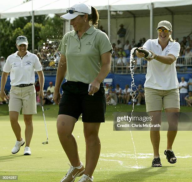 Charlotta Sorenstam sprays champagne over Karen Stupples on the 18th green as winner Annika Sorenstam watches on during day four of the ANZ Ladies...