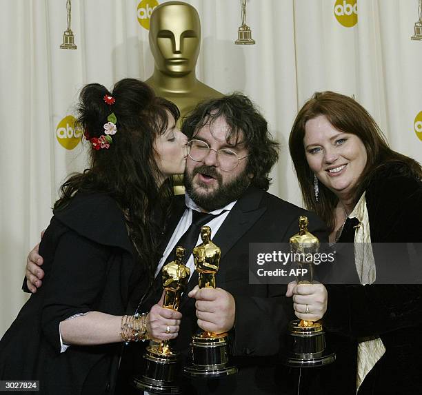 United States: Fran Walsh kisses director Peter Jackson, flanked by Philippa Boyens as they pose with the Oscar for Best Adapted Screenplay at the...