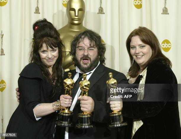 United States: Fran Walsh kisses director Peter Jackson, flanked by Philippa Boyens as they pose with the Oscar for Best Adapted Screenplay at the...