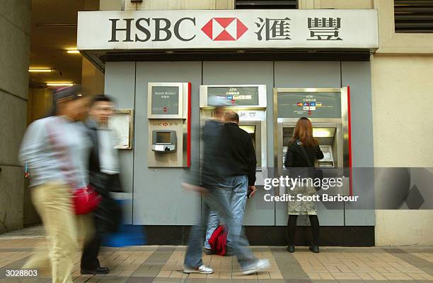 People withdraw money from a cash machine of the banking giant HSBC on December 11, 2003 in Hong Kong. The London-based bank, which operates in 79...