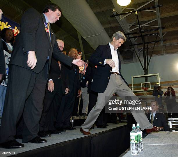 Democratic presidential candidate, US Senator John Kerry ,, gets some help from Montgomery County Executive Doug Duncan as he leaps on the stage...