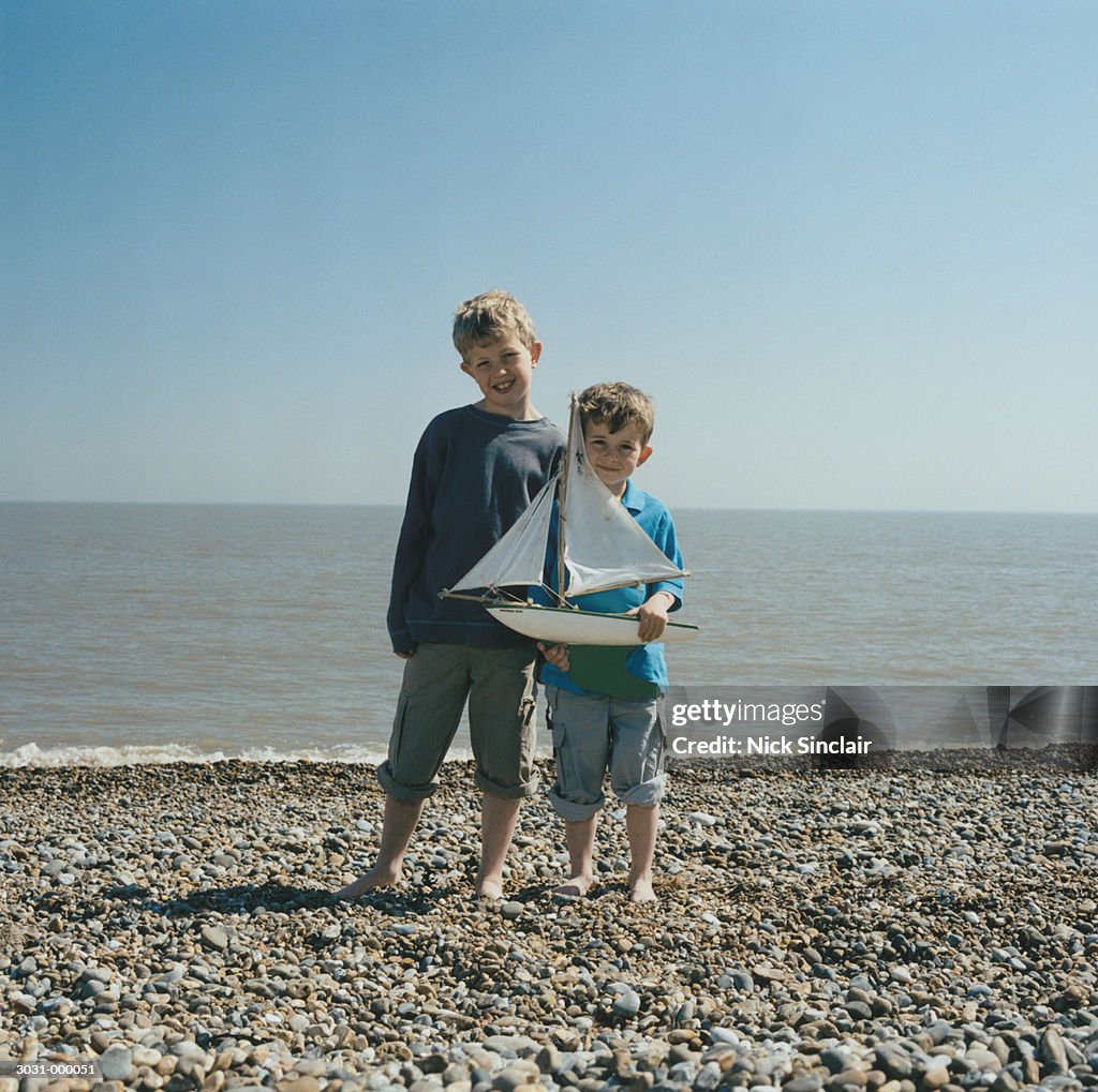 Two Boys Holding Toy Boat