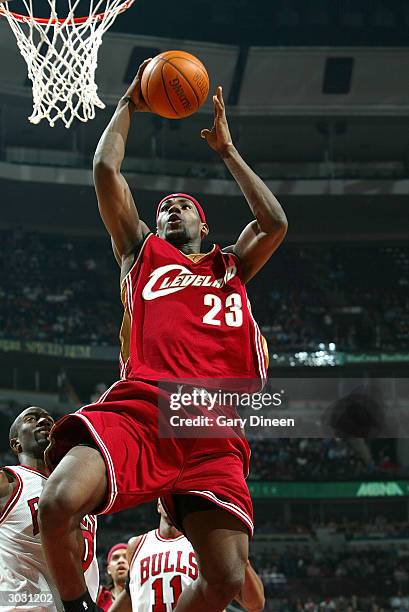 Lebron James of the Cleveland Cavaliers dunks over Ronald Dupree of the Chicago Bulls during the second quarter of a NBA game on March 1, 2004 at the...