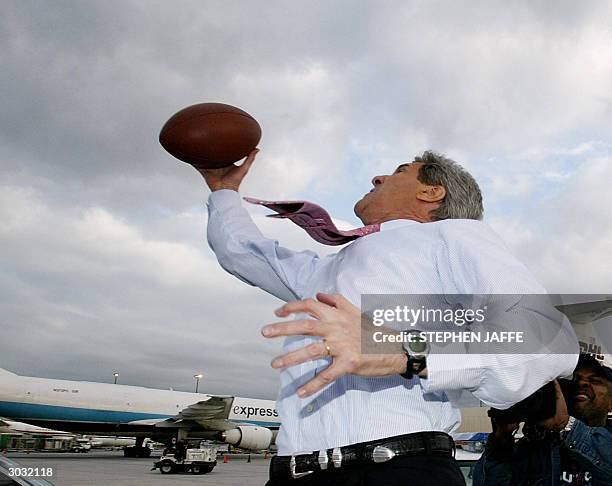 Democratic presidential candidate, Senator John Kerry plays football on the tarmac of Hartsfield Airport 02 March 2004 in Atlanta, Georgia. Kerry has...