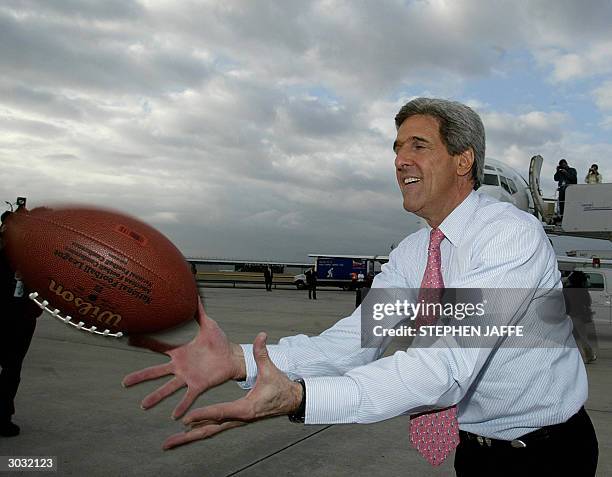 Democratic presidential candidate, Senator John Kerry plays football on the tarmac of Hartsfield Airport 02 March 2004 in Atlanta, Georgia. Kerry has...