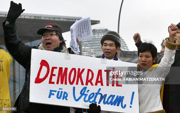 Members of a Vietnamese refugees association display a placard in front of the Chancellery to protest against the visit of general secretary of...