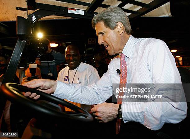 Democratic presidential candidate, Senator John Kerry ,,tries his hand at driving a forklift with the help of Chester Witchett at Roadway Express...