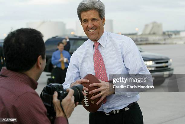 Democratic presidential candidate, Senator John Kerry , jokes with a photographer while playing with a football before his plane takes off from...