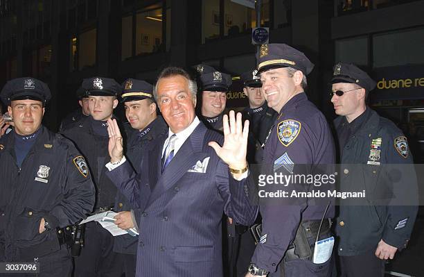 Actor Tony Sirico gestures as he stands near New York City police officers before entering Radio City Music Hall for the premiere of "The Sopranos"...