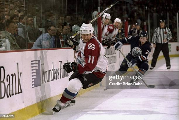 Right wing Keith Jones of the Colorado Avalanche and defenseman Janne Niinimaa of the Edmonton Oilers in action during a playoff game at the...