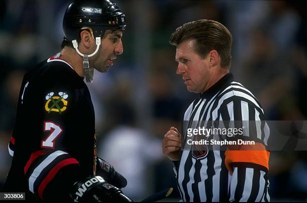 Defenseman Chris Chelios of the Chicago Blackhawks talks with referee Kerry Fraser during a game against the Dallas Stars at Reunion Arena in Dallas,...