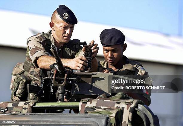 French soldiers load ammo into a machine gun mounted on the lead vehicle of a convoy leaving the city's airport as they escorted newly arrived...