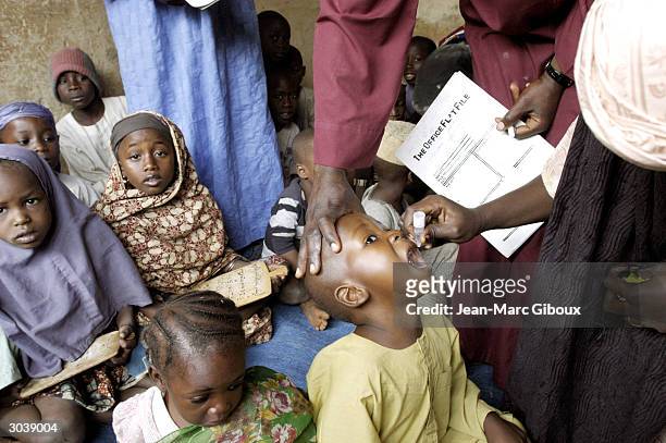 Health workers immunize children against polio inside a Koranic school in the old city of Kano during the National Immunization Days November 13,...