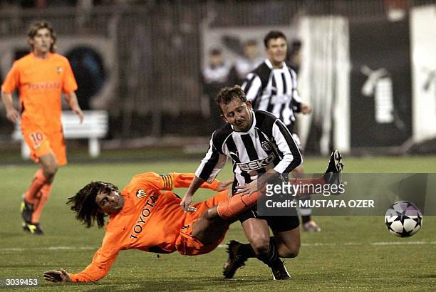 Besiktas Istanbul's Sergen Yalcin is tackled by Valencia's Fabian Ayala during their UEFA Cup third round second leg football match, 03 March 2004 in...