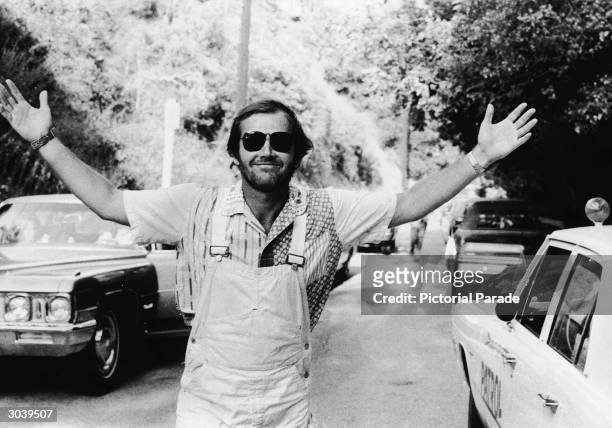 American actor Jack Nicholson smiles with his arms outstretched, wearing overalls and sunglasses, while attending the Motion Picture Relief Fund...