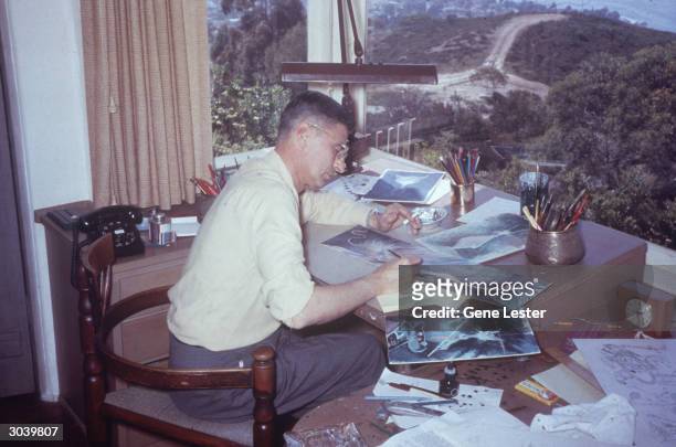 American author and illustrator Dr. Seuss , works on illustrations for one of his children's books at his desk at home in La Jolla, California, April...